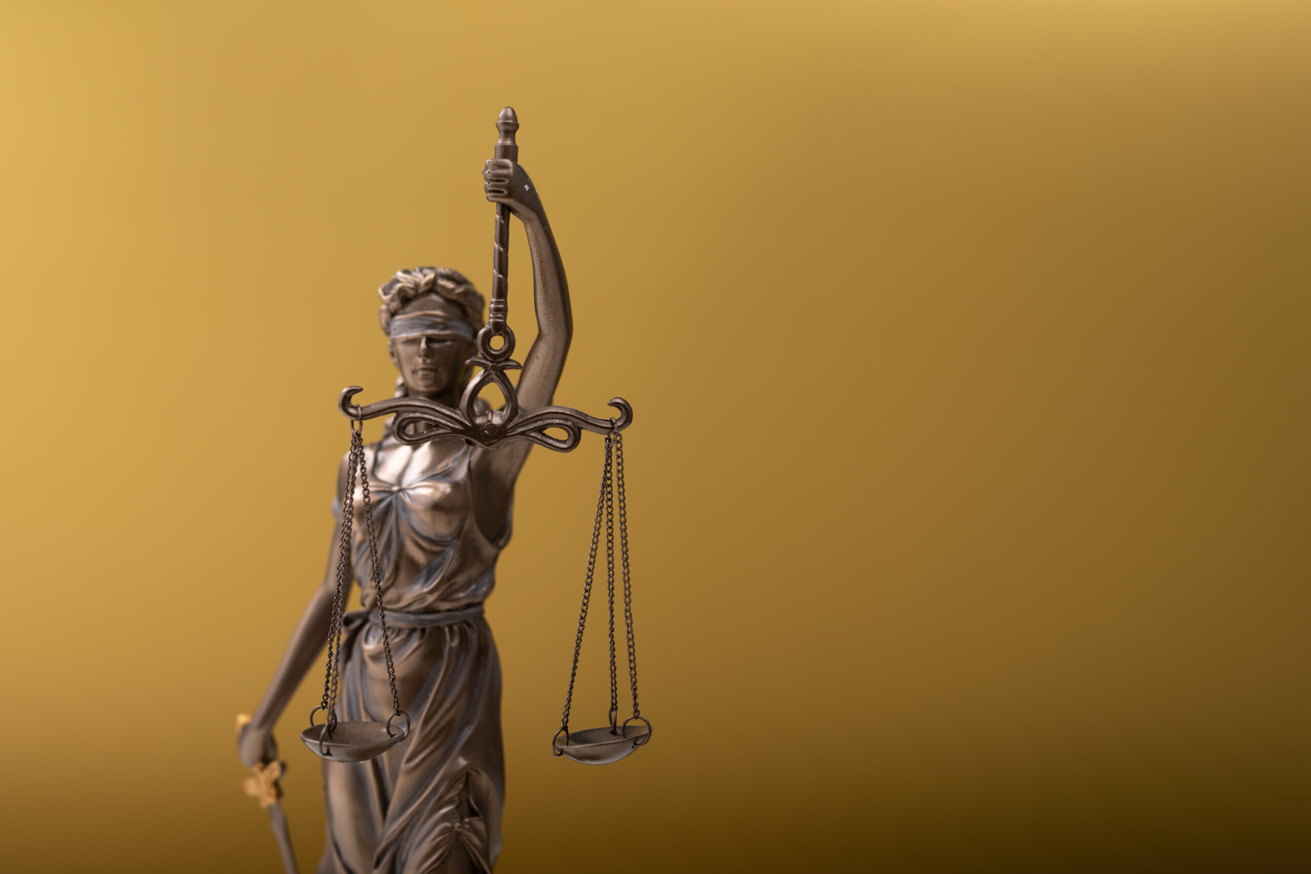 A statue of lady justice statue on a golden background